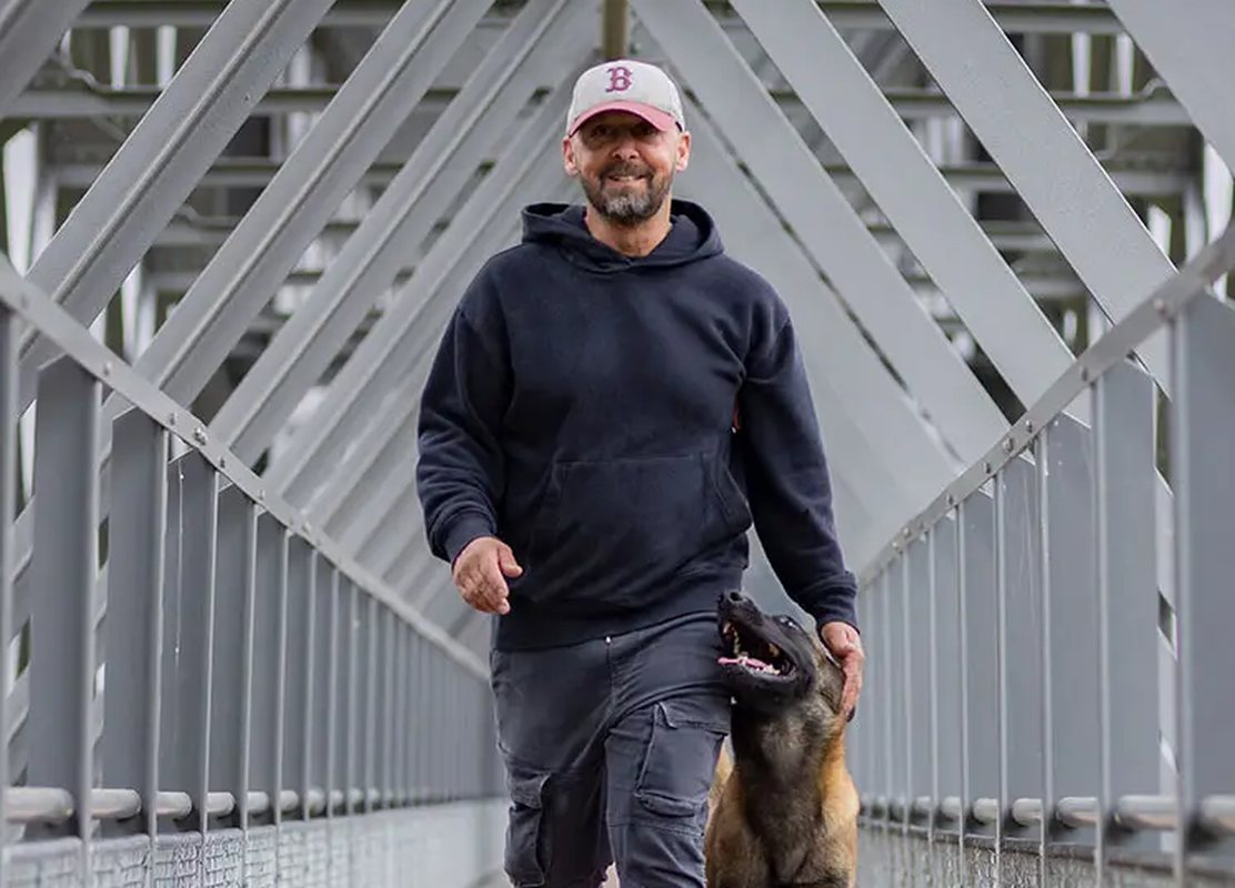 Marcel Cannon geht mit seinem Malinois entspannt an lockerer Leine über eine Brücke